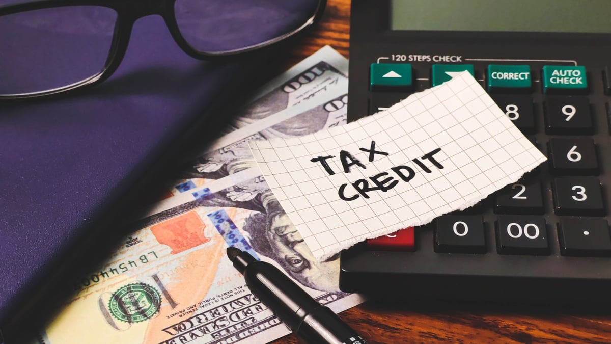 Tax Credit Calculation: Financial Planning with Money, Calculator, and Notebook